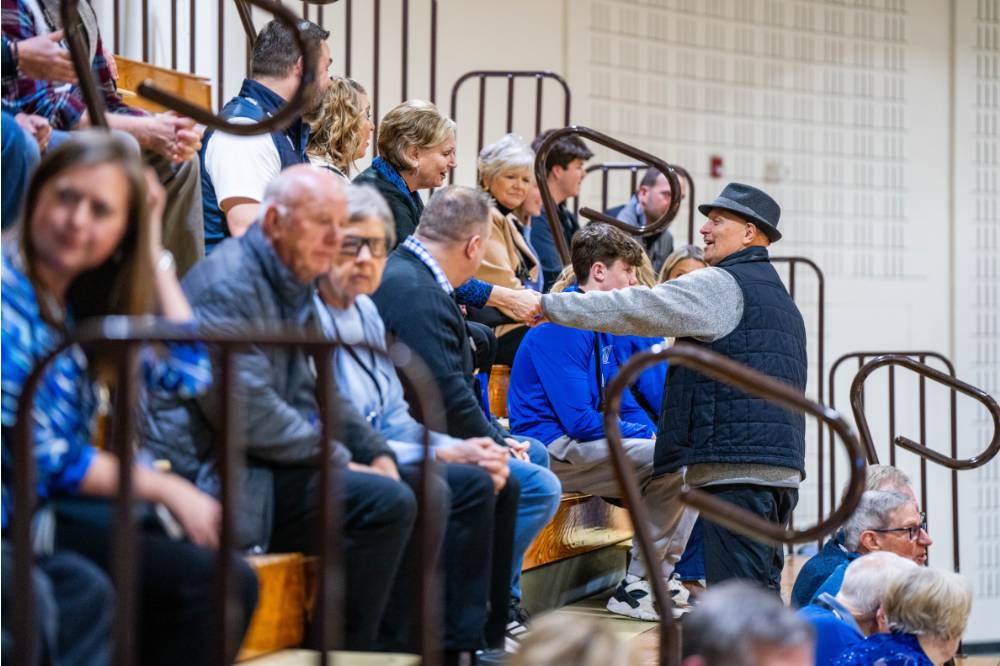 Guests greet each other in the stands